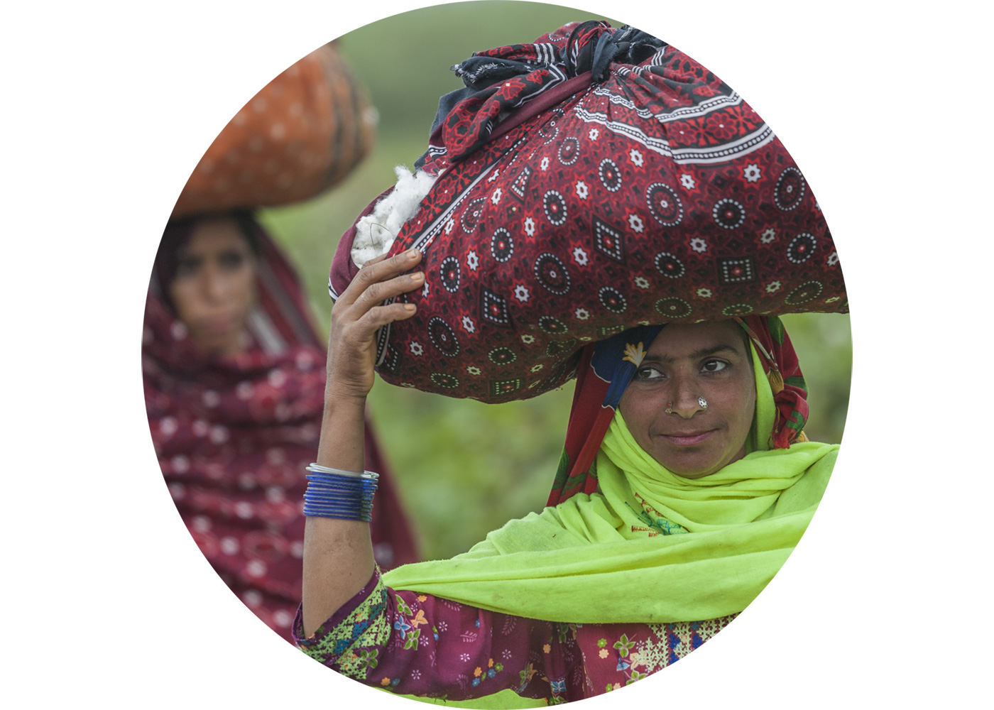 Women carrying recently picked, responsibly grown cotton in textile bags on their heads.