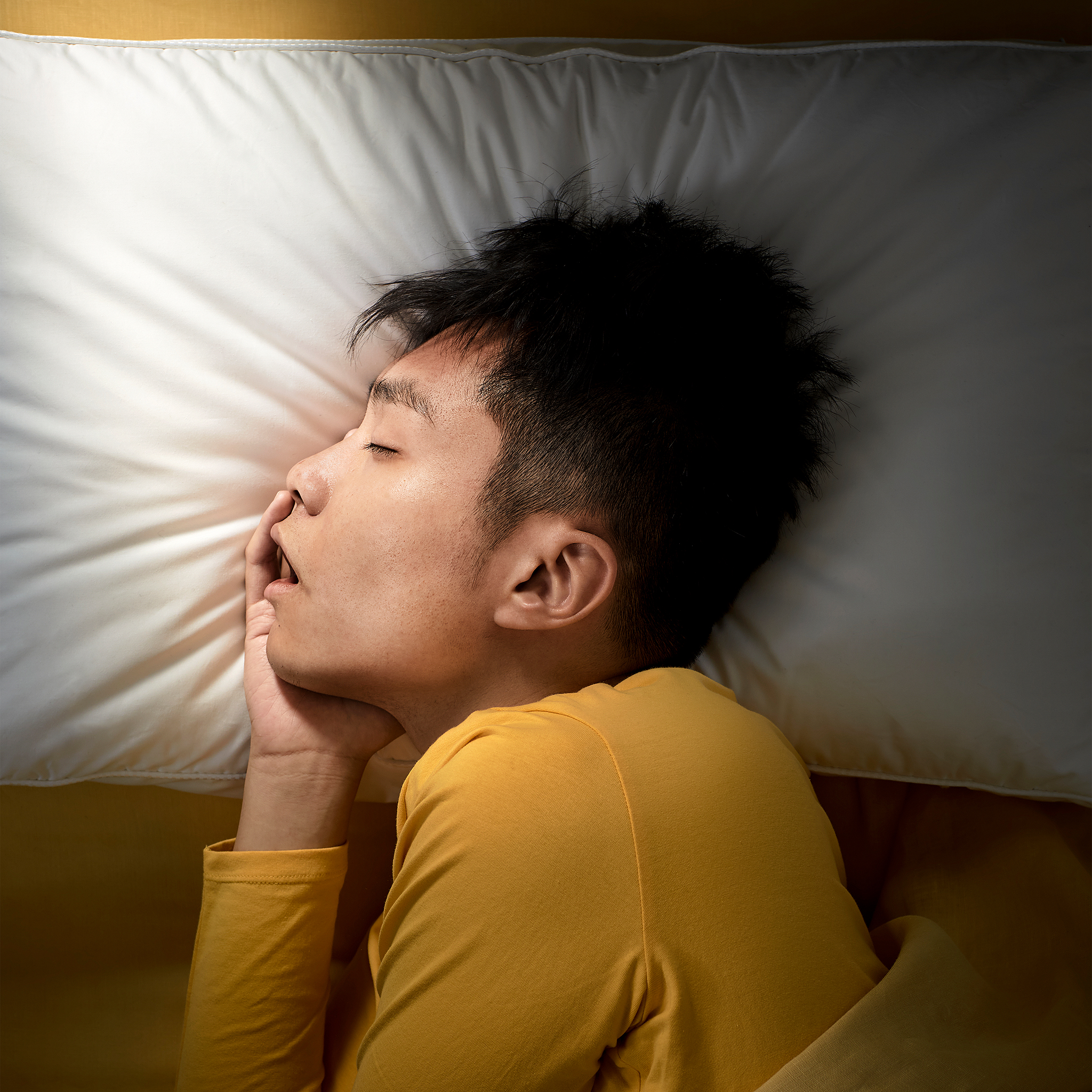 一位青年侧躺着枕在宜家 PRAKTVÄDD 普拉科特维德 人体工学枕上,睡得很沉。
